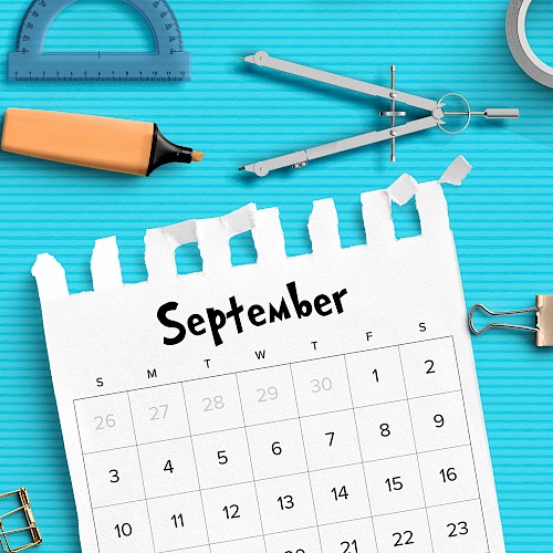 A September calendar page on a blue background with various stationery items like a protractor, highlighter, compass, and tape.